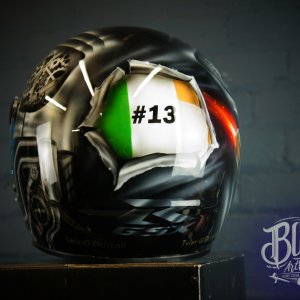 Black motorcycle helmet with airbrushed Irish tricolour flag design incorporating #13 number and skull elements in green white orange